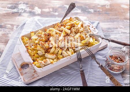Pasta Penne mit Putenfleisch, geräucherter Käse und Gewürzen in Keramik. Traditionelle Gerichte der italienischen Küche. Stockfoto