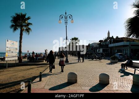 LARNACA, ZYPERN - Januar 2, 2017: Leute entlang Finikoudes Strand bummeln in Larnaca an einem sonnigen Tag im Januar. Stockfoto