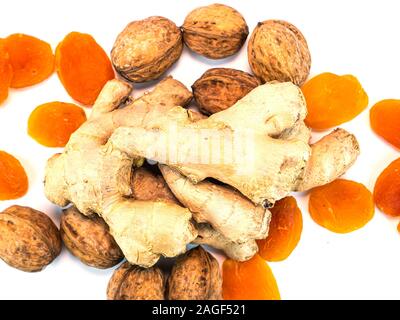 Ingwer Wurzel mit Walnüssen und getrocknete Aprikosen Aprikosen auf einem weißen Hintergrund. Essen Foto. Für Text platzieren. Ethnoscience. Stockfoto