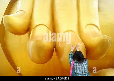 Frau Berühren mit dem Finger des Großen Buddha Bild für den Segen, Wat Muang Tempel, Provinz Ang Thong, Thailand Stockfoto