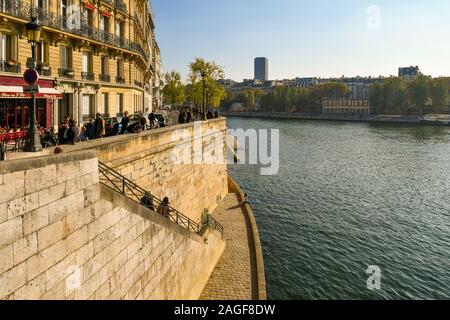 Einen malerischen Blick auf den Fluss Seine von Pont Saint-Louis Brücke mit Menschen und Touristen im Quai d'Orléans River Bank auf der Ile Saint-Louis, Paris, Frankreich Stockfoto