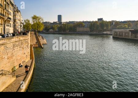 Einen malerischen Blick auf den Fluss Seine von Pont Saint-Louis Brücke mit Menschen und Touristen im Quai d'Orléans River Bank auf der Ile Saint-Louis, Paris, Frankreich Stockfoto