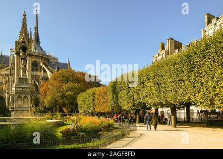 Blick auf Johannes XXIII. Garten auf der Rückseite der Kathedrale von Notre Dame mit der Jungfrau Brunnen und die Menschen entspannen in einem sonnigen Herbst Tag, Paris, Frankreich Stockfoto