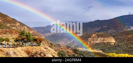 Helle Regenbogen an einem regnerischen Tag in Südkalifornien, Hügel und Täler in Chaparral abgedeckt; Pyramid Lake, Los Angeles County, Kalifornien Stockfoto