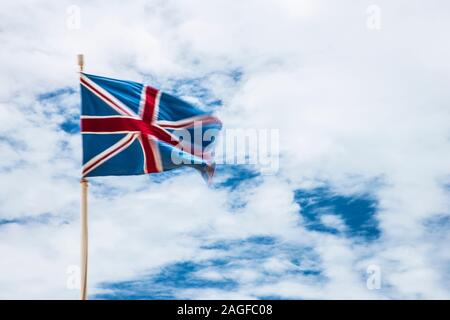 Ein Union Jack Flagge im Wind flattern gegen einen Sommer Himmel. Stockfoto