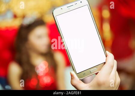 Bildschirm des Telefons ist weiß und Sie können Text schreiben. Das Mädchen hält einen gold Telefon in der Hand. Stockfoto