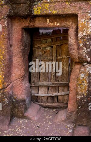 Äthiopien, Amhara-region, Lalibela, Arbatu Ensessa, Biblia Chirkos Kirche, hölzerne Tür in festen Stein Wand Stockfoto