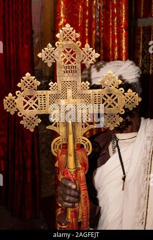 Äthiopien, Amhara-region, Lalibela, Arbatu Chirkos Ensessa, Biblia, alte Felsen gehauene Kirche, Priester, in denen sich große Bronze gegossen, Gebet Kreuz in Mas verwendet Stockfoto