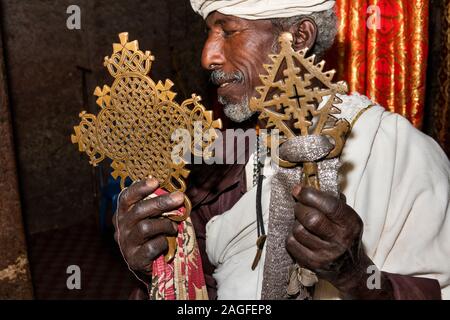 Äthiopien, Amhara-region, Lalibela, Arbatu Chirkos Ensessa, Biblia, alte Felsen gehauene Kirche, Priester mit zwei Bronze Gebet Kreuze in Masse verwendet Stockfoto