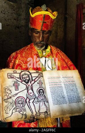 Äthiopien, Amhara-region, Lalibela, Arbatu Chirkos Ensessa, Biblia, Priester in Roben, die 800 Jahre alten beleuchteten Evangelium mit Kreuzigung image Stockfoto