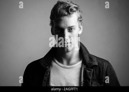 Gesicht der jungen gutaussehenden Mann mit lockigem Haar in den Farben Schwarz und Weiß Stockfoto