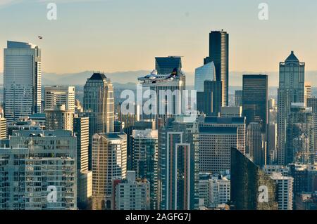 Bei Sonnenuntergang, dieses Foto zeigt ein Wasserflugzeug auf die Wolkenkratzer von Downtown Seattle fliegen an einem klaren Tag Stockfoto