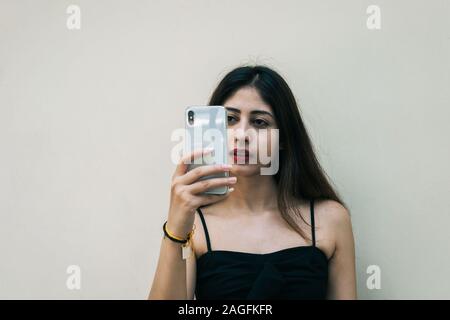 Indische weibliche Outdoor unter selfie mit Smart Handy auf isolierten Hintergrund Stockfoto