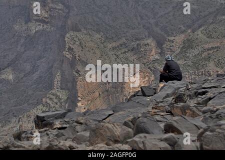 Omanische Mann betrachtet Wadi Ghul in der Nähe von Jebel Shams Stockfoto