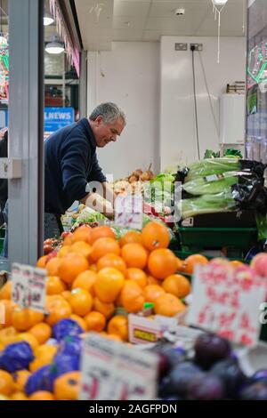 LEEDS, Großbritannien - 07 Dez, 2019: Eigentümer schwer bei der Arbeit im Stall Kirkgate Markt in Leeds, West Yorkshire, England auf Vicar Lane entfernt. Es ist der l Stockfoto