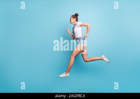 Volle Länge Körper Größe Foto der laufenden sportliche Mädchen streben, ihr Ziel zu erreichen, während mit blauem Hintergrund isoliert Stockfoto