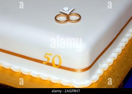 In der Nähe der Ecke der einstufige quadratischen Feier Kuchen bav Goldene Hochzeit - 50 Jahre Ehe - es zeigt zwei goldene Ringe und Zahlen 50 Stockfoto