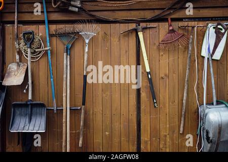 Schaufeln rechen Hämmer hängen an die Holzwand Stockfoto