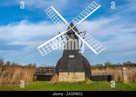 Alte Wind Pumpe und WIcken fen mit hohen Feuchtgebiet Gräser an einem sonnigen Tag. Stockfoto