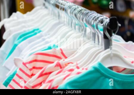 Unschärfe-effekte im Hintergrund Hintergrund bokeh, Sommer Baumwolle Kleider auf Kleiderbügeln hängen. Textilbekleidung SB-Warenhaus, Baumwolle Kleidung aus natürlichen gemacht Stockfoto