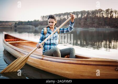 Reisen Frau paddeln im Kanu auf dem See Stockfoto