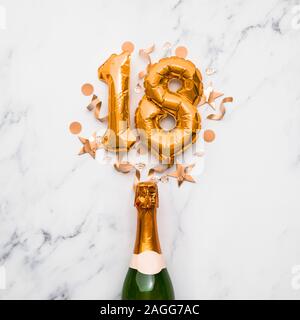 Champagner Flasche mit gold Nummer 18 Ballon. Minimal party Jubiläum Konzept Stockfoto