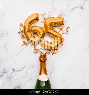 Champagner Flasche mit gold Nummer 65 Ballon. Minimal party Jubiläum Konzept Stockfoto