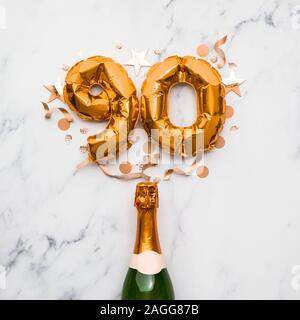 Champagner Flasche mit gold Nummer 90 Ballon. Minimal party Jubiläum Konzept Stockfoto