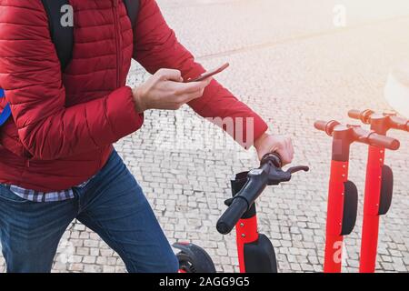 Mann mit einem Telefon in der Nähe der modernen Stadt elektrische kick Scooter Stockfoto