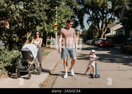 Familie von vier, Spaziergang in der Nachbarschaft Stockfoto
