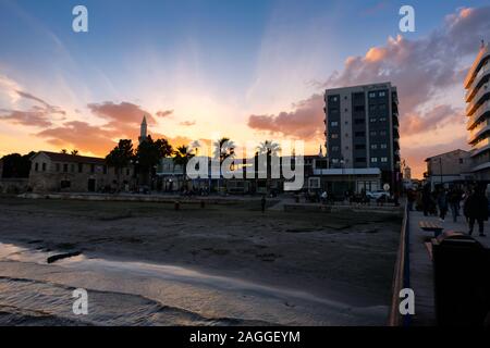 Larnaca, Zypern - 2. Januar 2018: Sonnenuntergang über der Stadt Larnaca vom Pier aus gesehen. Blick Richtung Finikoudes Beach und Larnaca Castle. Stockfoto