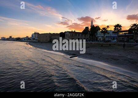 Larnaca, Zypern - 2. Januar 2018: Sonnenuntergang über der Stadt Larnaca vom Meer gesehen. Blick Richtung Finikoudes Beach und Larnaca Castle. Stockfoto