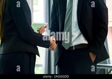 Geschäftsleute, die Hände zu schütteln, bis eine Papiere zu unterschreiben. Konferenz-, Vertrags- und Rechtsanwalt Beratung Konzept. Stockfoto