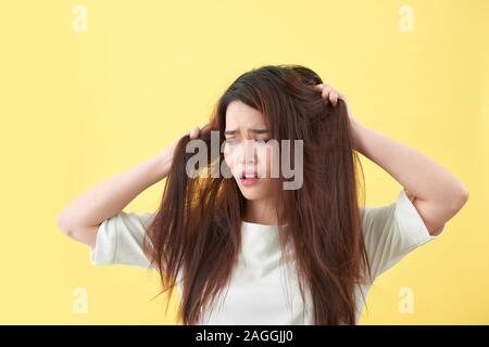 Frau mit geschädigtem Haar die Hand und suchen. Isolierte Porträt Stockfoto