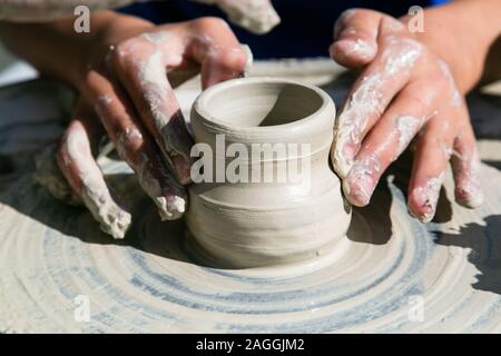 Womans Hände Arbeiten aus Keramik mit Ton auf der Töpferscheibe Stockfoto