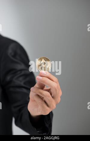 Mannes Hand mit goldenen Bitcoin isoliert auf weißem Hintergrund Stockfoto