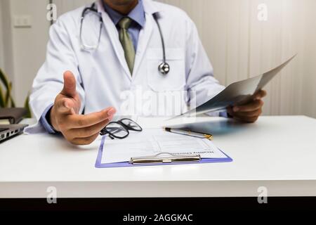 Ein Arzt berät Patienten, während am Tisch im Büro zu sitzen. Medizin und Gesundheit Konzept. Stockfoto