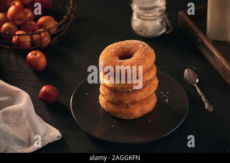 Auf einem dunklen Holz- Oberfläche mit einem schwarzen Hintergrund donuts gestapelt werden Stockfoto
