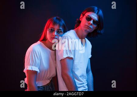 Paar im dunklen Zimmer mit roten und blauen Neon Beleuchtung Stockfoto