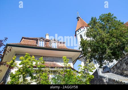 Die Stadtkirche Thun und Gebäude im historischen Zentrum von Thun, Schweiz. Die Reformierte Kirche hat einen schönen mittelalterlichen Turm und einem barocken Gang. Schweizer touristische Attraktion. Stockfoto