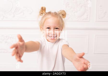 Kleine blonde Mädchen zieht ihre Arme heraus für eine Umarmung. Stockfoto