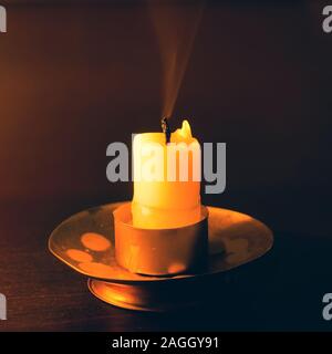 Erloschene Kerze auf einem Holztisch in der Nacht Stockfoto