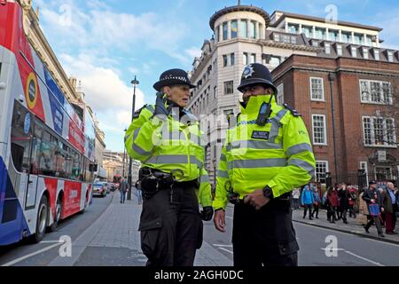 Polizistin und Polizist im Gespräch im Gespräch in der Straße in der Nähe der Piccadilly Street Fortnum & Mason West London England UK KATHY DEWITT Stockfoto