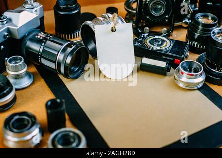 Closeup retro Mockup, Clip Board mit Papier und Label. Retro Vintage Fotozubehör und quipments herum auf Holz- Hintergrund. Stockfoto