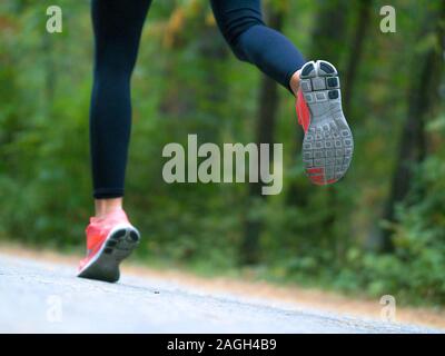 Frau läuft in den Wald. Füße eines Läufers. Close-up von Sneakers. Helathy Lebensstil. Stockfoto