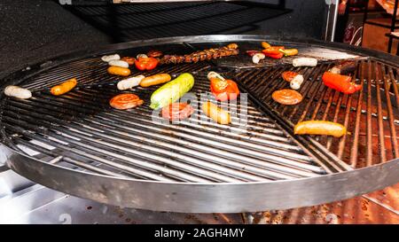 In Scheiben geschnittene Paprika, Zucchini und Fleisch kochen auf Grill, im Freien. Picknick mit Grillen im Freien. Fleisch gebraten auf Metallgitter. Stockfoto