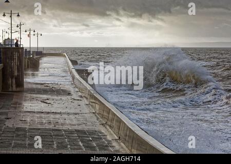 Im Bild: Ein einsamer Mann steht die Wellen gegen die Promenade Wand in Porthcawl, Wales, Großbritannien zu beobachten. Dienstag, 01 Oktober 2019 Re: Schwere Regen- und st Stockfoto