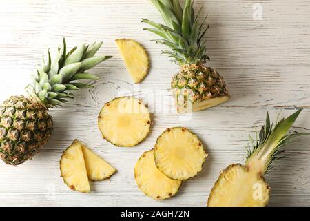 Ananas und Schichten auf weißem Holz- Hintergrund, Ansicht von oben Stockfoto