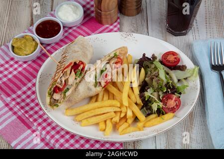 Gesundes Essen. Chicken Wrap mit Gemüse. BBQ Chicken mit frischem Salat Tortilla Wraps auf rustikalen Hintergrund. Stockfoto