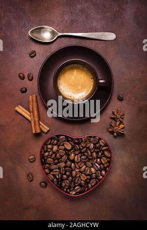 Zusammensetzung mit einer Tasse Espresso, und eine Herzförmige Schale mit Kaffeebohnen Stockfoto